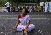File photo of a supporter of Tamil Nadu chief minister J Jayalalitha wails sitting on a road.