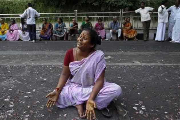 File photo of a supporter of Tamil Nadu chief minister J Jayalalitha wails sitting on a road.